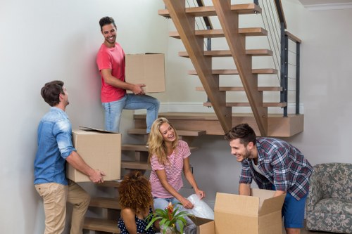 Professional movers carrying furniture in a South East London home